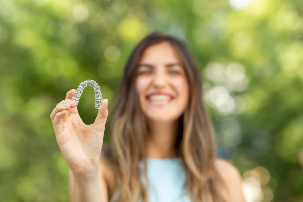 Beautiful,Smiling,Turkish,Woman,Is,Holding,An,Invisalign,Bracer