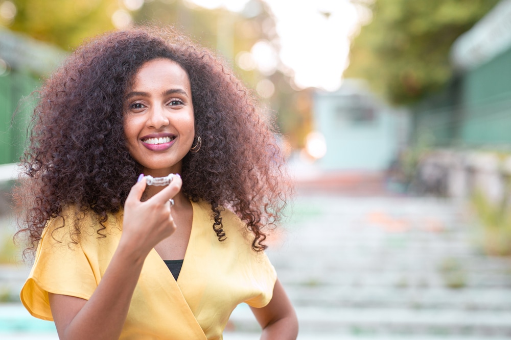 Beautiful,Smiling,African,Black,Woman,Is,Holding,Invisaligner.,Includes,Copy